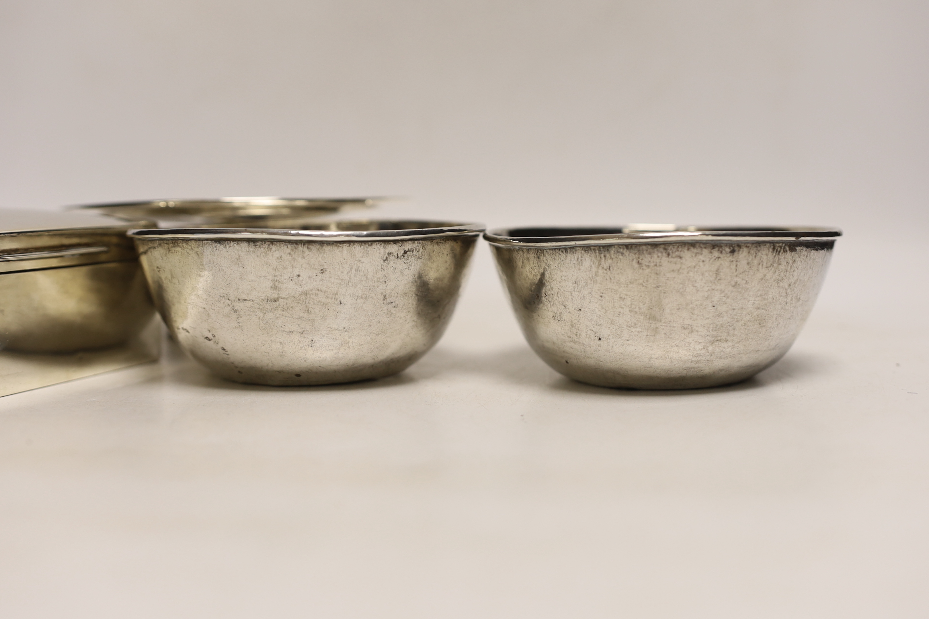 An Edwardian silver mounted cigarette box, London, 1901, 10.8cm, a small silver tazza and two continental white metal bowls, with inset coin bases.